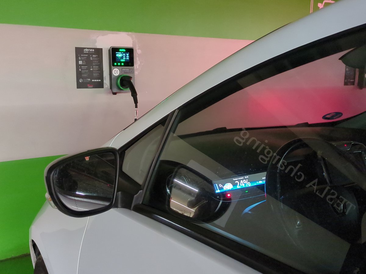 Cotxe elèctric endollat en un carregador d’un centre comercial